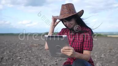 智慧生态是一种收获农业的耕作理念。 女农民用生活方式数字平板电脑研究地球上的泥土